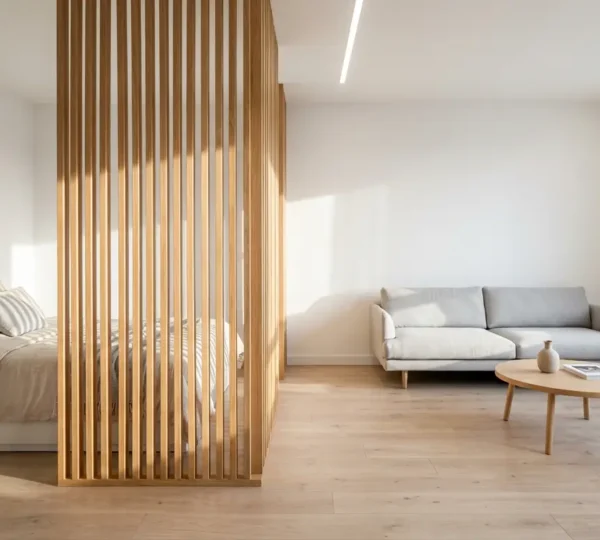 Un studio lumineux avec un claustra en bois naturel séparant harmonieusement l'espace nuit du salon